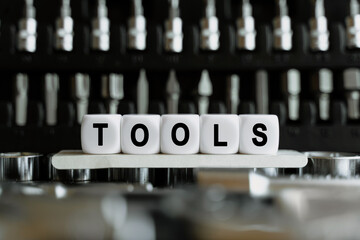 Against the background of a set of tools, white cubes with the inscription - tools
