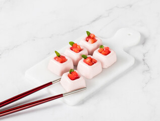 Strawberry cream dessert, Panna Cotta in the form of small square portions, on a serving board....