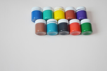 Closed jars with gouache of different colors. Creativity, hobby. Learning to draw. A set of gouache...