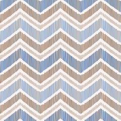 Seamless pattern with hand drawn chevron design. Modern ikat print with blue and brown stripes.
