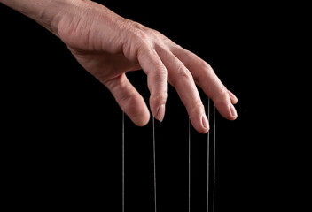 Hand closeup pulling strings, manipulating, controlling. Authority concept. High quality photo