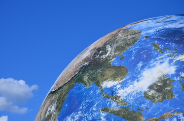 Planet Earth model against blue sky