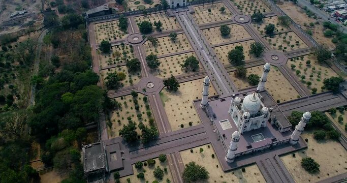 Aerial shot of white marble mausoleum, huge garden with aligned trees