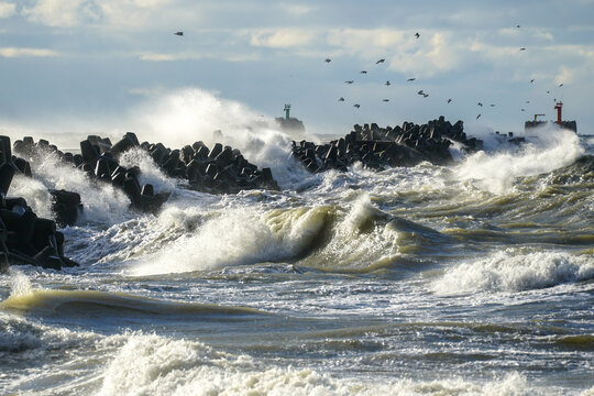 Big waves created during stormy weather crash against the breakwater concrete tetrapods