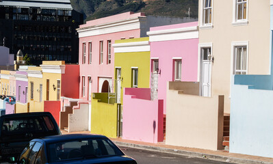 Street of distinctive pastel colored buildings in district of Bo=Kaap in Cape Town.