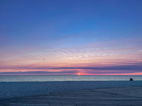Beautiful sunset or sunrise iver the sea. Colorful cloud band above the horizon.