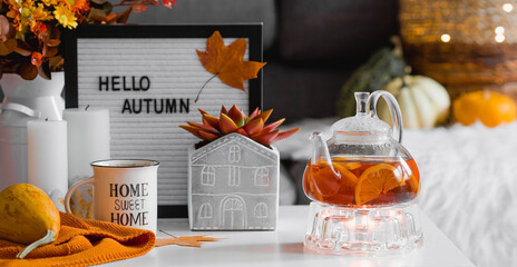Cozy autumn concept. Home warmth in cold weather. Still-life. A blanket, pumpkins, a teapot and a...