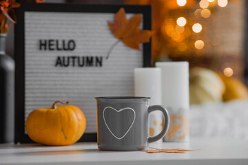 Cozy autumn concept. Home warmth in cold weather. Still-life. A blanket, pumpkins, flowers and a...