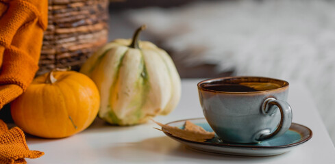 Cozy autumn concept. Home warmth in cold weather. Still-life. A blanket, pumpkins, flowers and a...