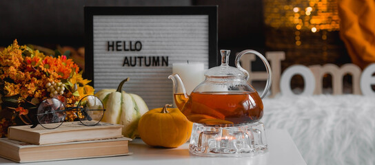 Cozy autumn concept. Home warmth in cold weather. Still-life. A blanket, pumpkins, a teapot and a...