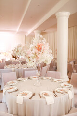 festive wedding decoration. Beautiful fresh white and pink flowers in glass vase on dining table on wedding day. High quality photo