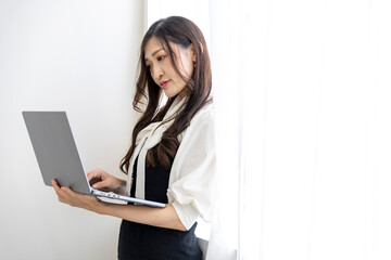 A working Japanese woman by remote work in the home office closeup
