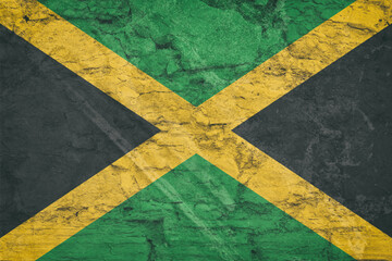 Flag of Jamaica on stone wall, grunge background. Flag of Jamaica depicted in bright paint colors on old relief plastering wall