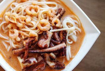 Spicy Asian soup with noodles, octopus and shrimp.