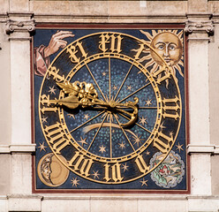 Fototapeta na wymiar Antique clock with golden hands, numbers, moon and sun on the facade of a Renaissance building in Munich