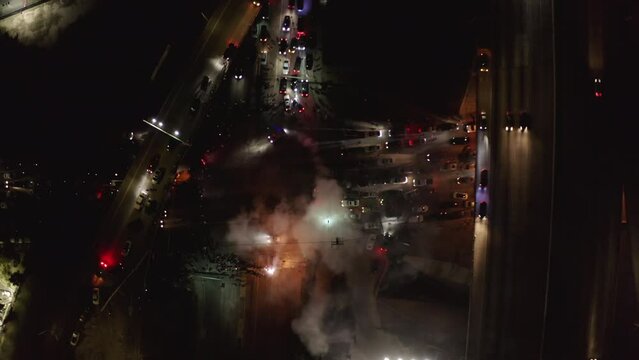 Aerial Lockdown Time Lapse Shot Of Smoke Emitting From Sports Cars During Competition In City At Night -  Los Angeles, California