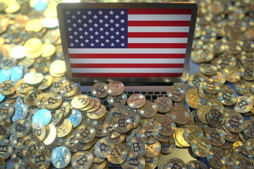 Flag of the USA on the laptop screen and many bitcoins. National cryptocurrency regulations and crypto mining concepts, 3d rendering