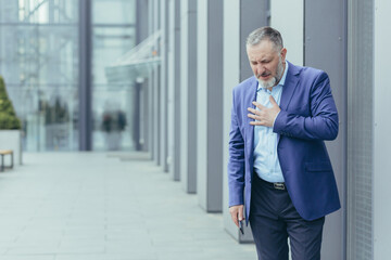 Senior gray-haired banker boss sick outside office building, banker has severe chest pain, heart...