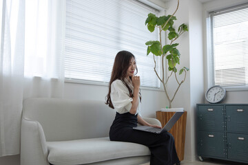 A Japanese woman checking smartphone by remote work in the home office