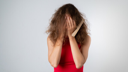 The woman covered her face with her hands - stress due to naughty, brittle and tangled hair