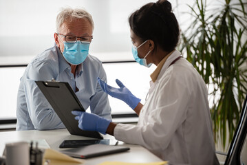 Doctor specialist consulting a patient in a doctor's office at a clinic. Female doctor is talking...
