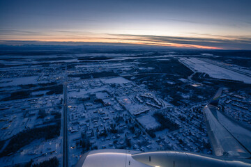 Snow covered frozen Alaska landscape in winter sunset. View from the airplane