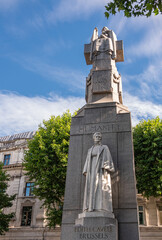 Fototapeta na wymiar London, UK- July 4, 2022: Off Trafalgar Square. Closeup of Edith Cavell Memorial is stone obelisk with Marble statues featuring her image and appealing humanity on St. Martin Place.