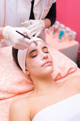 Obraz na płótnie Canvas Girl with facial mask lying in beauty health spa center and getting skin beauty treatment 