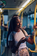 African american woman using smartphone while riding a bus in the night