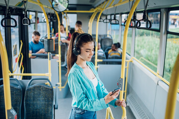 Woman paying a bus ticket via smartphone during a ride