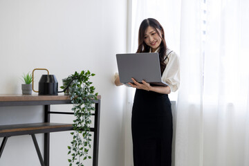 A Japanese woman checking smartphone by remote work in the home office