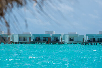 Tropical bungallow on blue turquouise sea water in luxury resort island in Maldives 2022