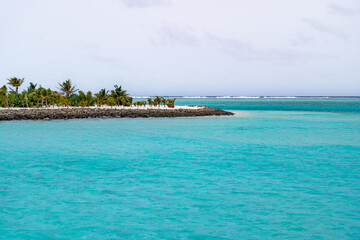 Fototapeta premium Beautiful bay breakwater, with rocks, white sand, palm trees, turquoise water and blue sky in tropical Maldives island