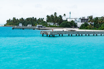 Fototapeta na wymiar Concrete Pier and dock at tropical beach bay with turquoise water in Maldives Island 2022 