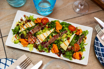 Traditional Mediterranean salad of fresh lettuce with romesco sauce, anchovy fillets and cheese...