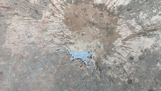 large splatter of water on a textured rough gray floor or wall - abstract splash background with abstract pattern texture of dry concrete during a drought