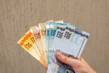 Brazil money. hand holding Brazilian banknotes