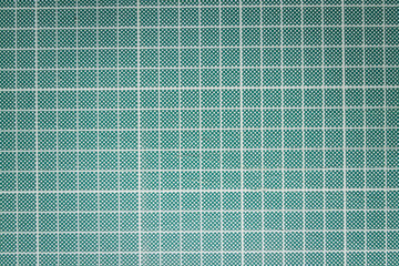 Close up of a dark green and light grid craft cutting board