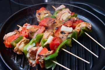 Close-up of some meat and vegetable skewers being grilled on a grill