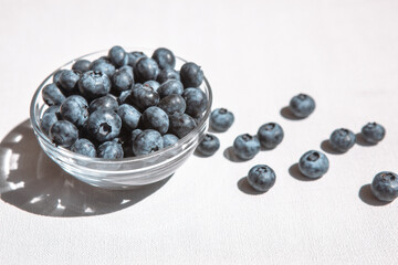 Fresh blue blueberry on white table, card with organic sweet food