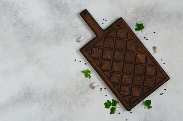 culinary background for the design with copy space for text, empty wooden handmade cutting board top view and spices pepper, garlic and green parsley, handmade dish flat lay and mock up