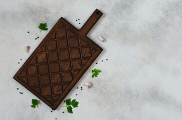 culinary background for the design with copy space for text, empty wooden handmade cutting board top view and spices pepper, garlic and green parsley, handmade dish flat lay and mock up