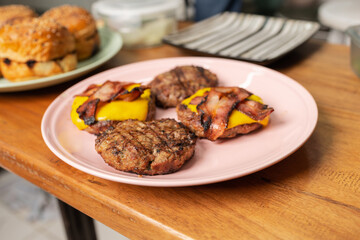 Dish with grilled hamburgers with cheese and bacon on top