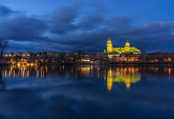 Fototapeta na wymiar Panoramic view and reflections on the water of the city of Salamanca (Spain) at night.