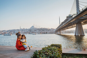 Fototapeta premium happy sister sitting down with the view of bosphorus sea and city of istanbul turkey
