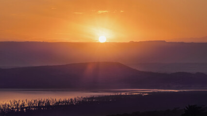 Fototapeta na wymiar sunrising over mountain with foreground of Lake Nakuru Kenya