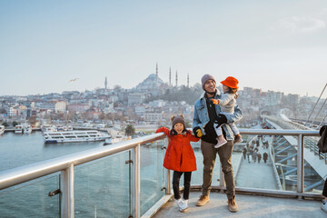 Naklejka premium father and daughter travel to turkey. portrait of dad and kid enjoying the view of beautiful istanbul turkey from the bridge