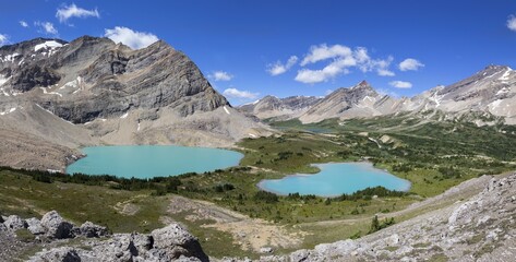 Panoramic Alpine Landscape View with Twin Teal colored Lakes and Rocky Mountain Peaks Skyline. 
Sunny Day Scenic Summertime Hiking Banff National Park, Canadian Rockies