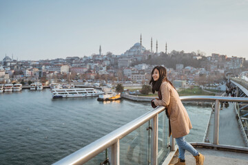 Naklejka premium woman tourist enjoying the view of istanbul cityscape from top of the bridge