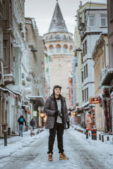 Fototapeta na wymiar asian man standing in the city of istanbul during snow winter time